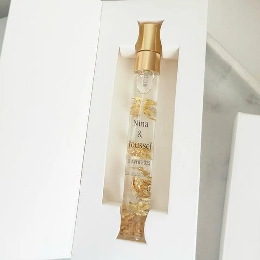Musc royal personnalisé avec éclats d'or dans un flacon élégant, présenté en coffret blanc raffiné.