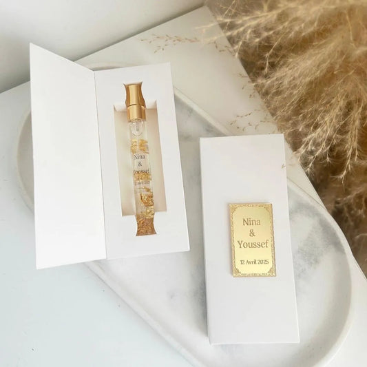 Musc royal personnalisé avec éclats d'or dans un flacon élégant, présenté en coffret blanc raffiné.